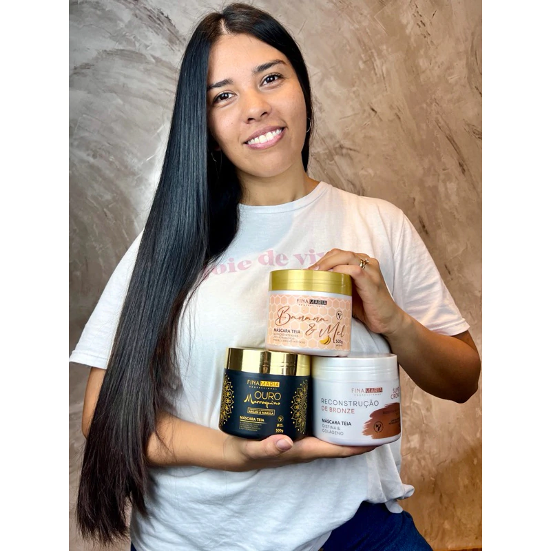 Cliente de cabelo longo e liso segurando o kit Fina Maria